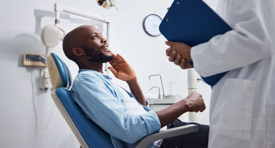 man holding his cheek at the dentist