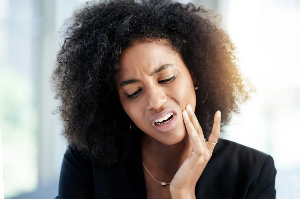 Woman showing signs of toothache
