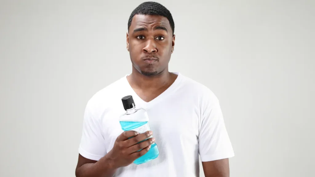 Black man using mouth wash